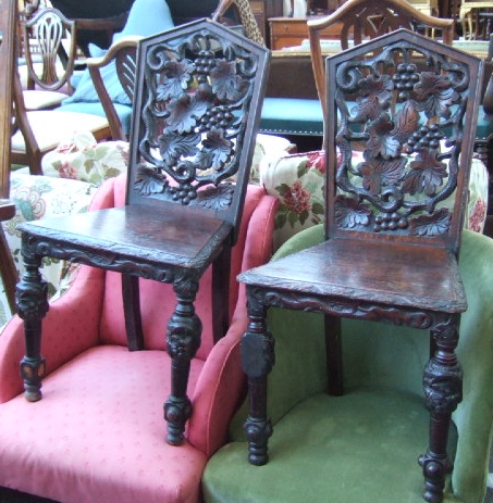 Appraisal: A pair of Victorian carved oak hall chairs the arched