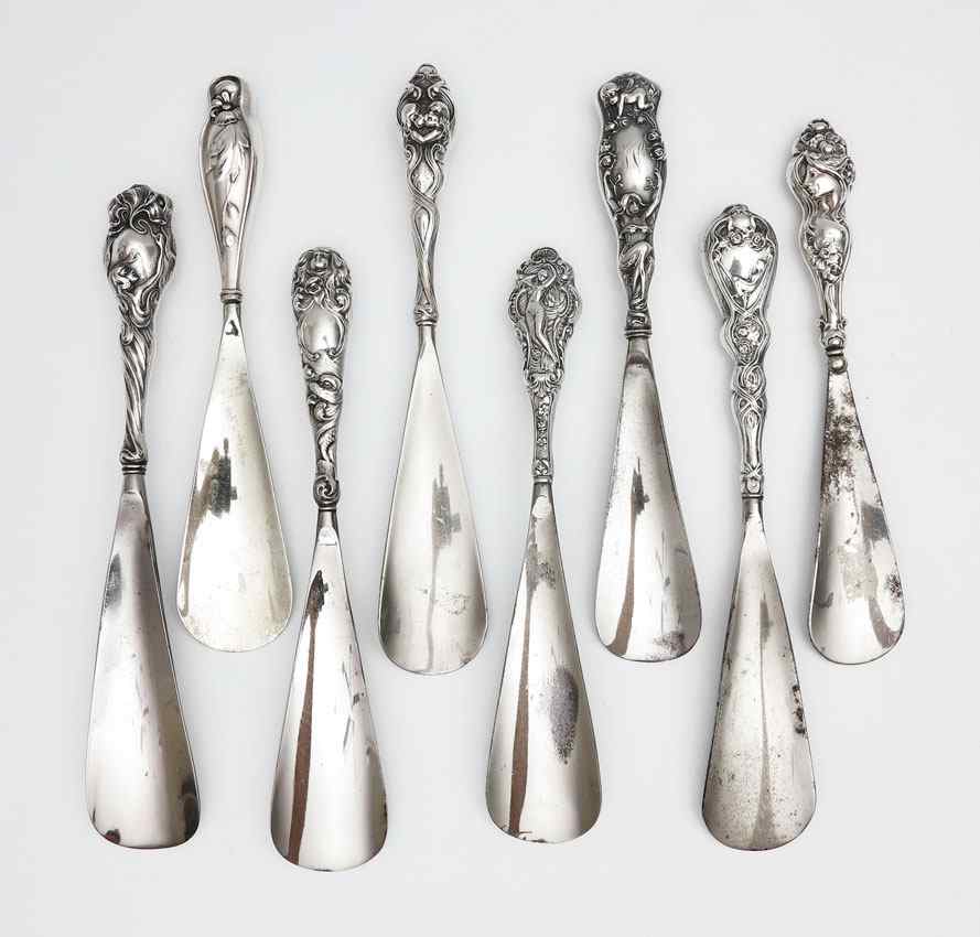 Appraisal: COLLECTION ART NOUVEAU STERLING SHOE HORNS To include Cupid atop