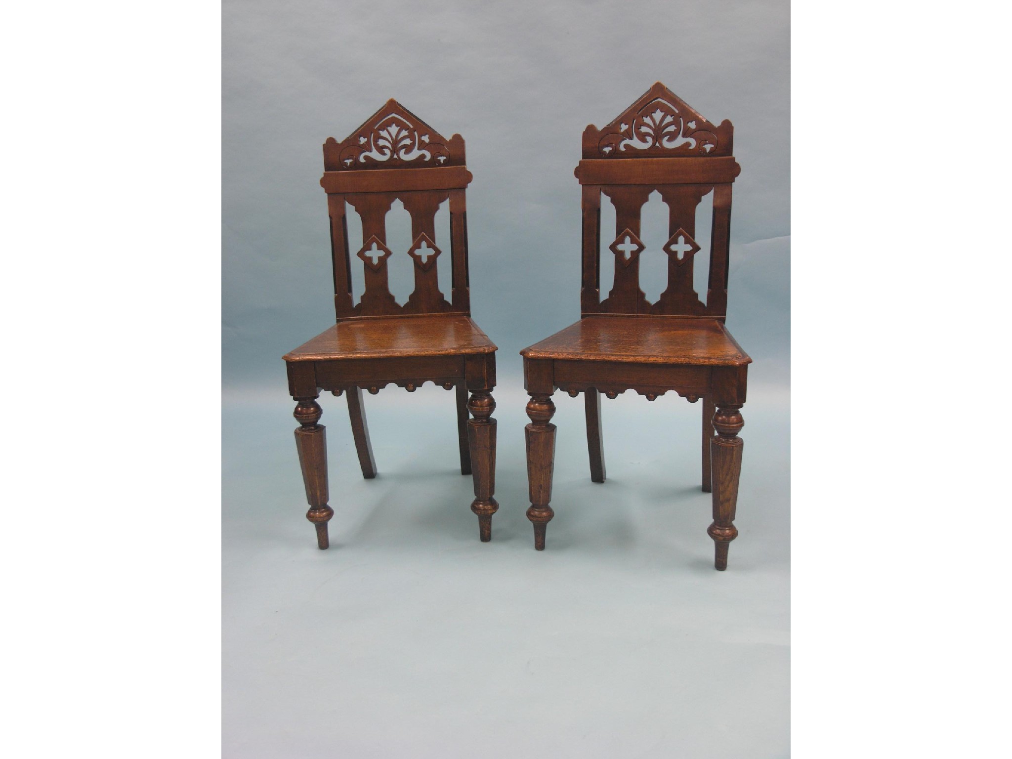 Appraisal: A pair of Victorian oak hall chairs pierced architectural backs