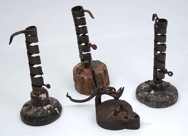 Appraisal: THREE ANTIQUE COILED IRON CANDLE STICKS with rustic wooden bases