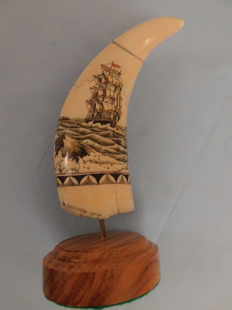 Appraisal: SCRIMSHAW MERMAID TOOTH Curved whale tooth on stand with scrimshaw