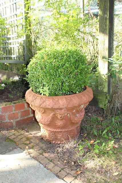 Appraisal: A SMALL TERRACOTTA PLANTER with moulded mask and fruiting swag