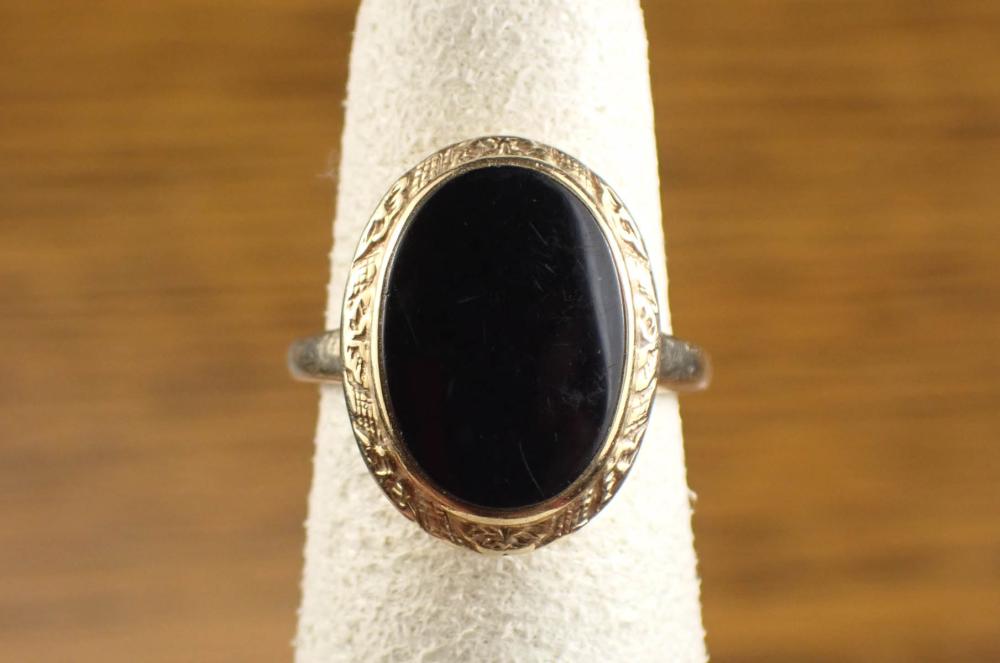 Appraisal: BLACK ONYX AND FOURTEEN KARAT GOLD RING bezel set with