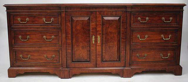 Appraisal: A GEORGIAN STYLE MAHOGANY BREAK FRONT SIDEBOARD with central cupboard