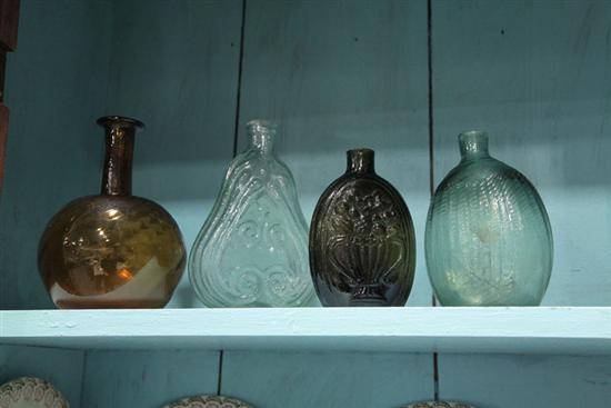 Appraisal: FOUR BLOWN GLASS BOTTLES A Clevenger Bros amber swirl bottle