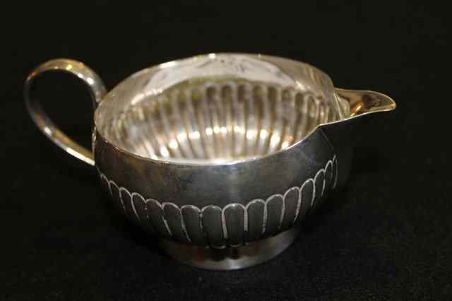 Appraisal: A SILVER JUG of fluted form with loop handle and