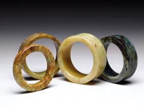 Appraisal: FOUR JADE AND HARDSTONE BANGLES Four Chinese carved jade and