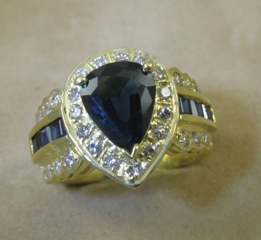 Appraisal: SAPPHIRE AND FOURTEEN KARAT GOLD RING centering a pear-cut dark