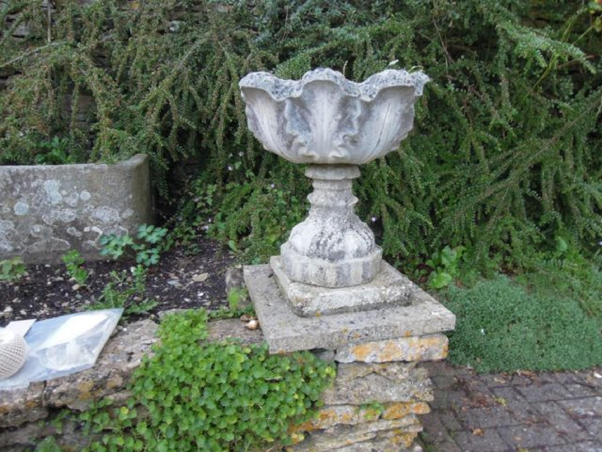 Appraisal: A pair of reconstituted weathered leaf moulded urns on shaped