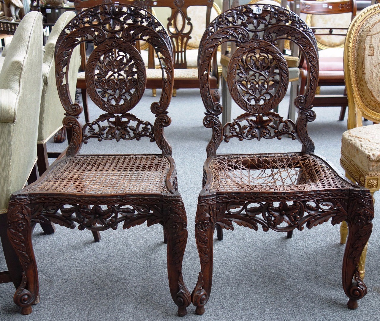 Appraisal: A pair of th century Indian profusely carved side chairs