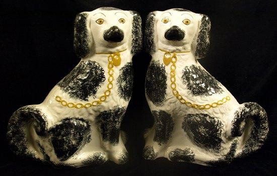 Appraisal: A pair of Staffordshire pottery dogs each in black and