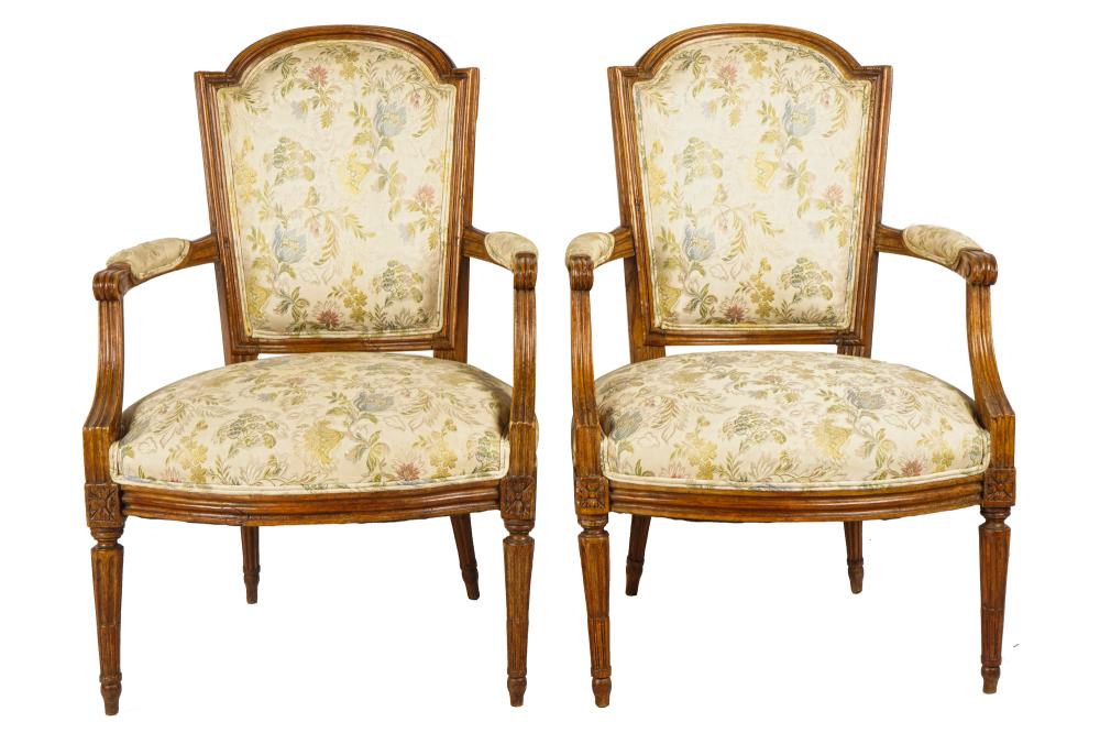 Appraisal: PAIR OF LOUIS XVI STYLE WALNUT FAUTEUILSwith cream-colored floral-patterned fabric