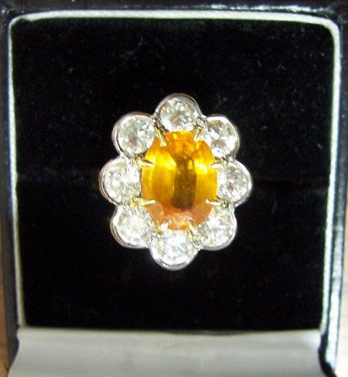 Appraisal: A yellow sapphire and diamond cluster ring the oval central