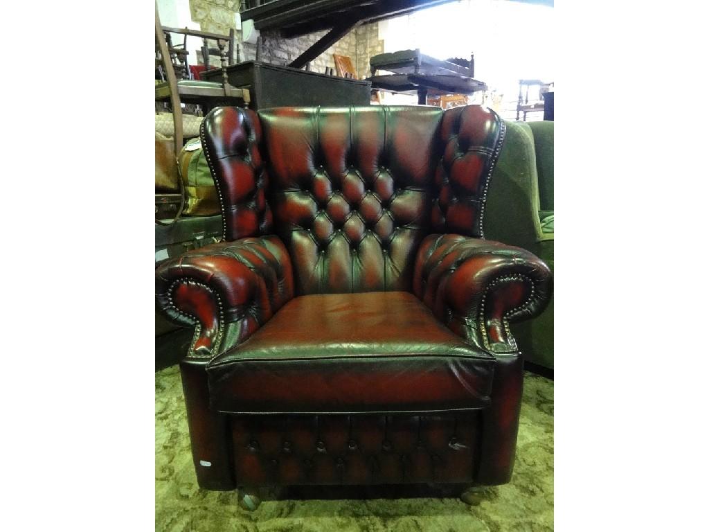 Appraisal: A contemporary wing armchair with red leather buttoned upholstery and