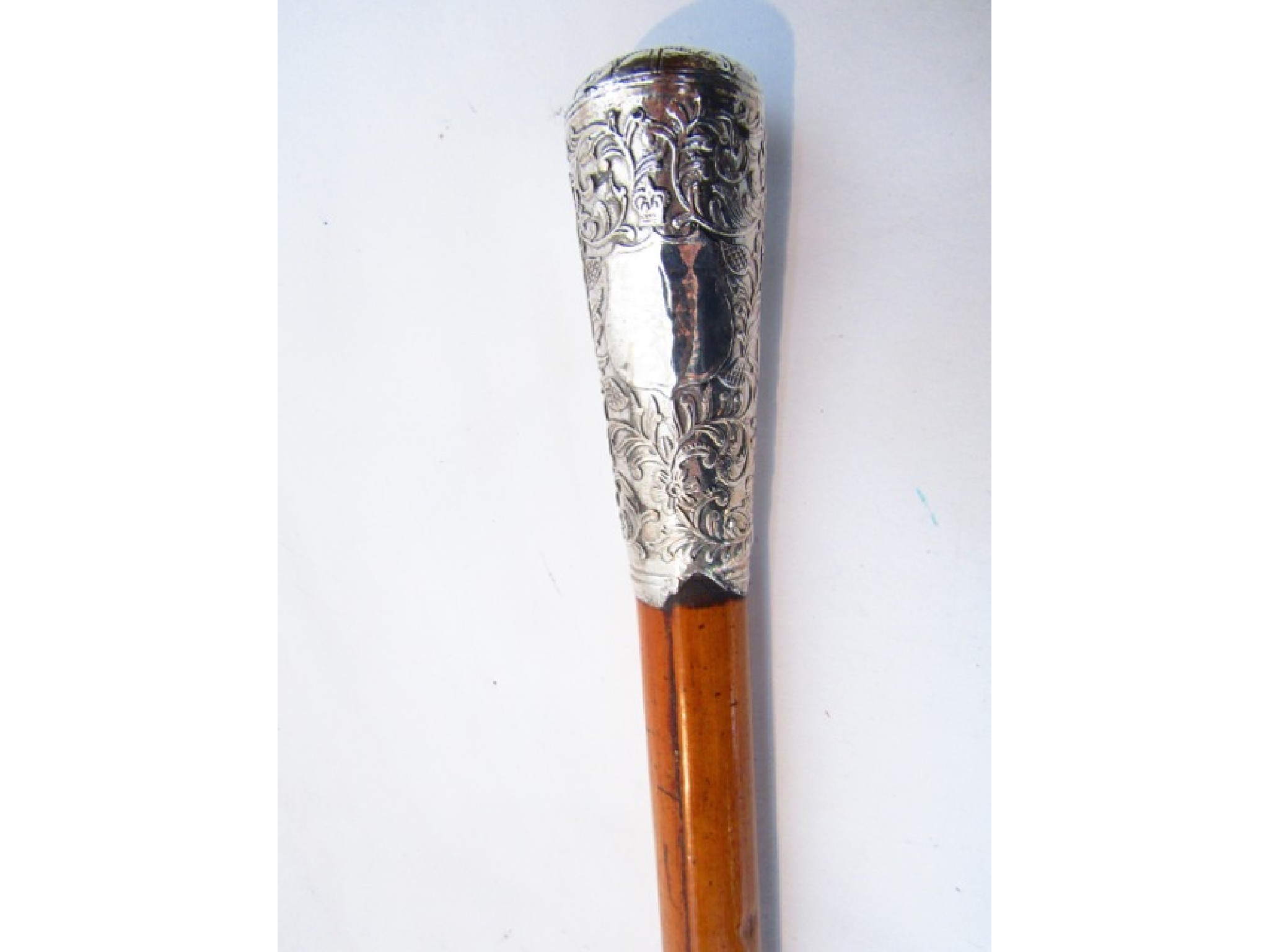 Appraisal: A Malacca shafted walking cane terminating in an embossed white