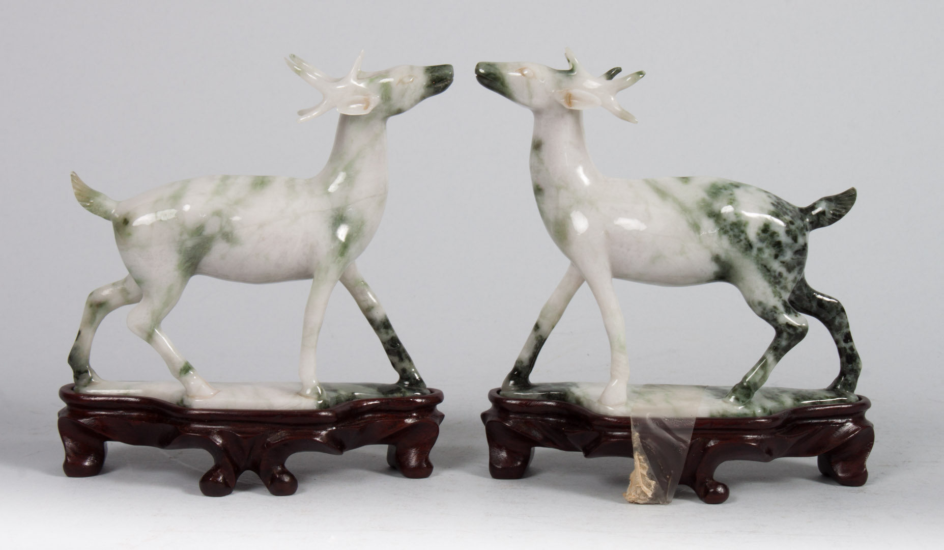 Appraisal: Pair of Chinese carved hardstone deer prancing deer on wood