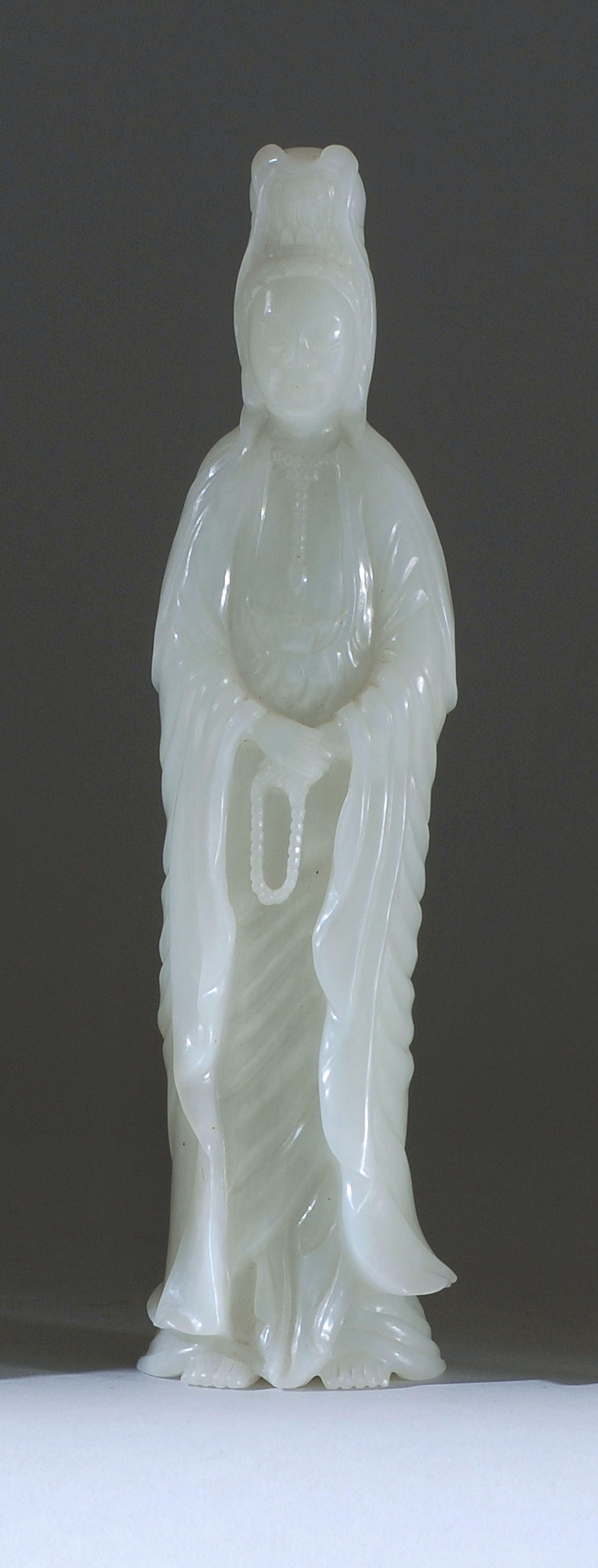 Appraisal: WHITE JADE FIGURE OF GUANYIN Circa In standing position holding