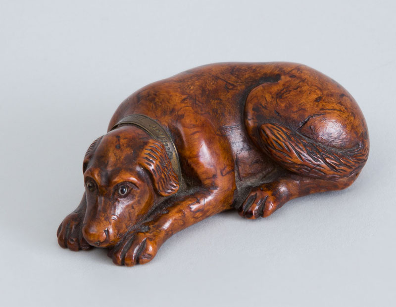 Appraisal: CONTINENTAL BRASS-MOUNTED CARVED WOOD SLEEPING HOUND-FORM SNUFF BOX Fitted with