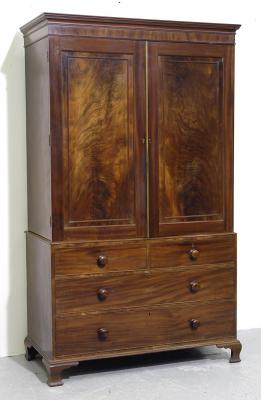 Appraisal: A MAHOGANY LINEN PRESS the cavetto moulded cornice over two