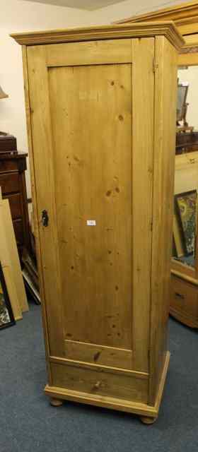 Appraisal: A STRIPPED AND WAXED PINE WARDROBE enclosed by single panel