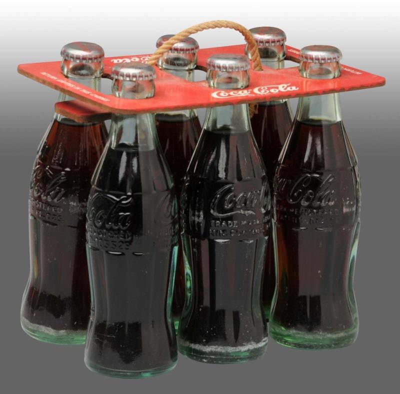 Appraisal: Coca-Cola -Pack Carrier with Bottles Description Includes six full Coca-Cola