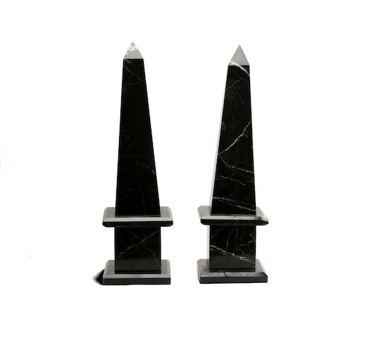 Appraisal: A pair of black marble obelisks Raised on simulated marble