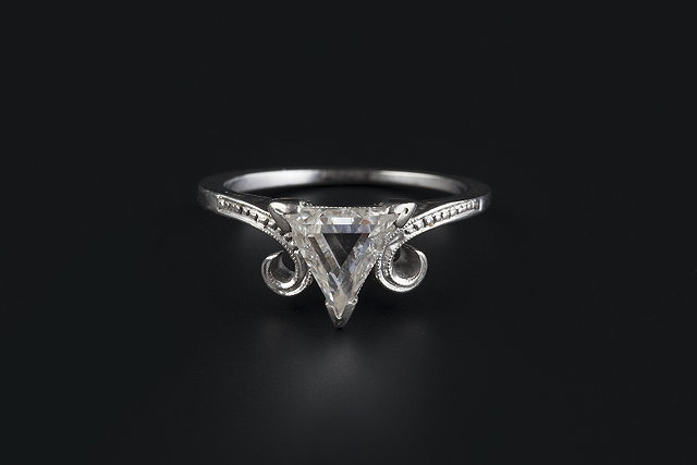 Appraisal: A diamond single stone ring the triangular step-cut diamond claw