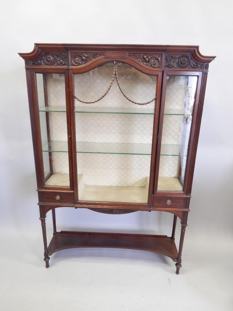 Appraisal: An Edwardian carved mahogany display cabinet with a shaped top