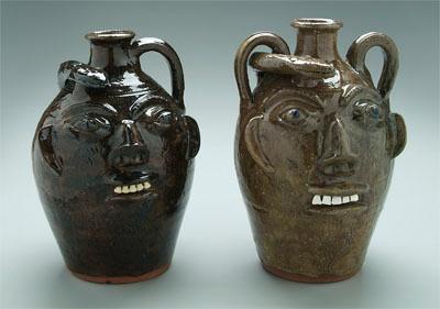 Appraisal: Two Walter Fleming face jugs one with dark olive glaze