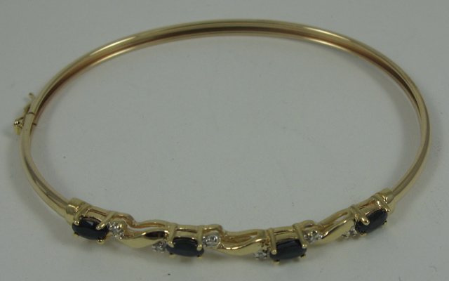 Appraisal: SAPPHIRE DIAMOND AND TEN KARAT GOLD BANGLE set with four