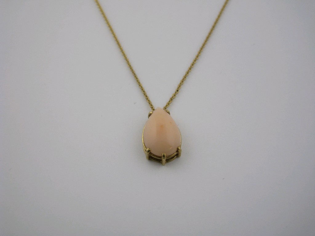 Appraisal: A pale pink Coral Pendant claw-set pear shaped cabochon in