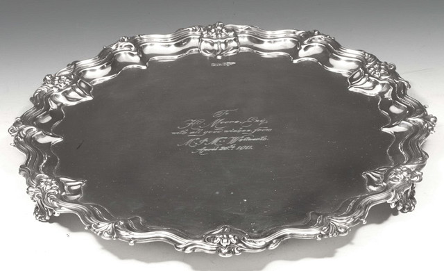 Appraisal: A SILVER SALVER with scroll and foliate border standing on