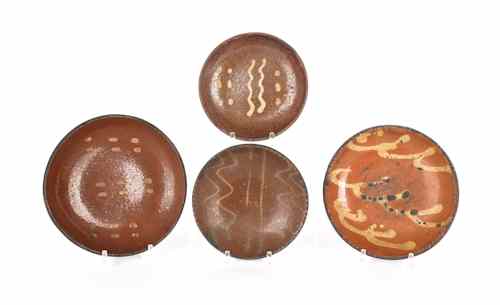 Appraisal: Four Pennsylvania slip decorated redware plates th c largest -