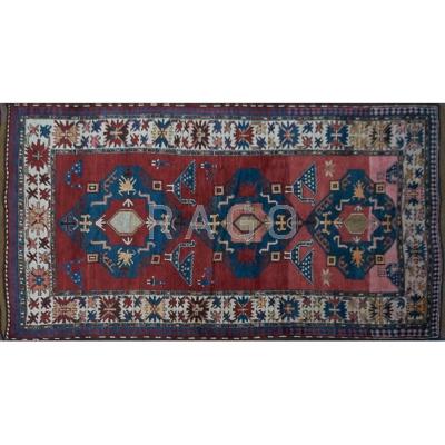 Appraisal: CAUCASIAN KAZAK Hand-knotted wool rug geometric pattern in ruby red