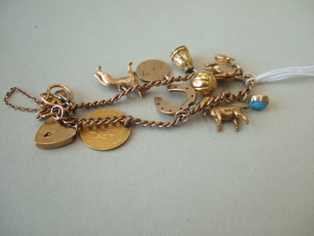 Appraisal: A gold curb link charm bracelet on a boltring clasp