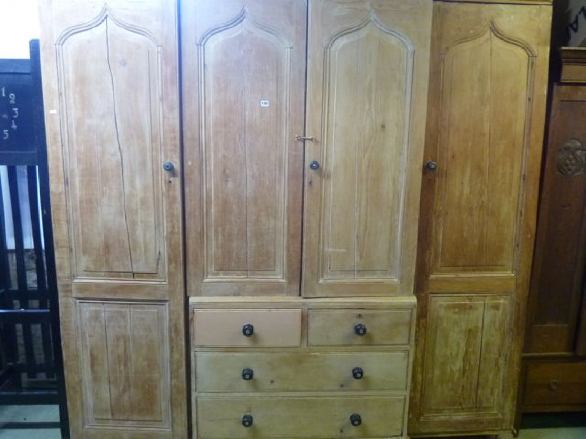 Appraisal: A substantial Victorian stripped pine sectional wardrobe the shallow breakfront