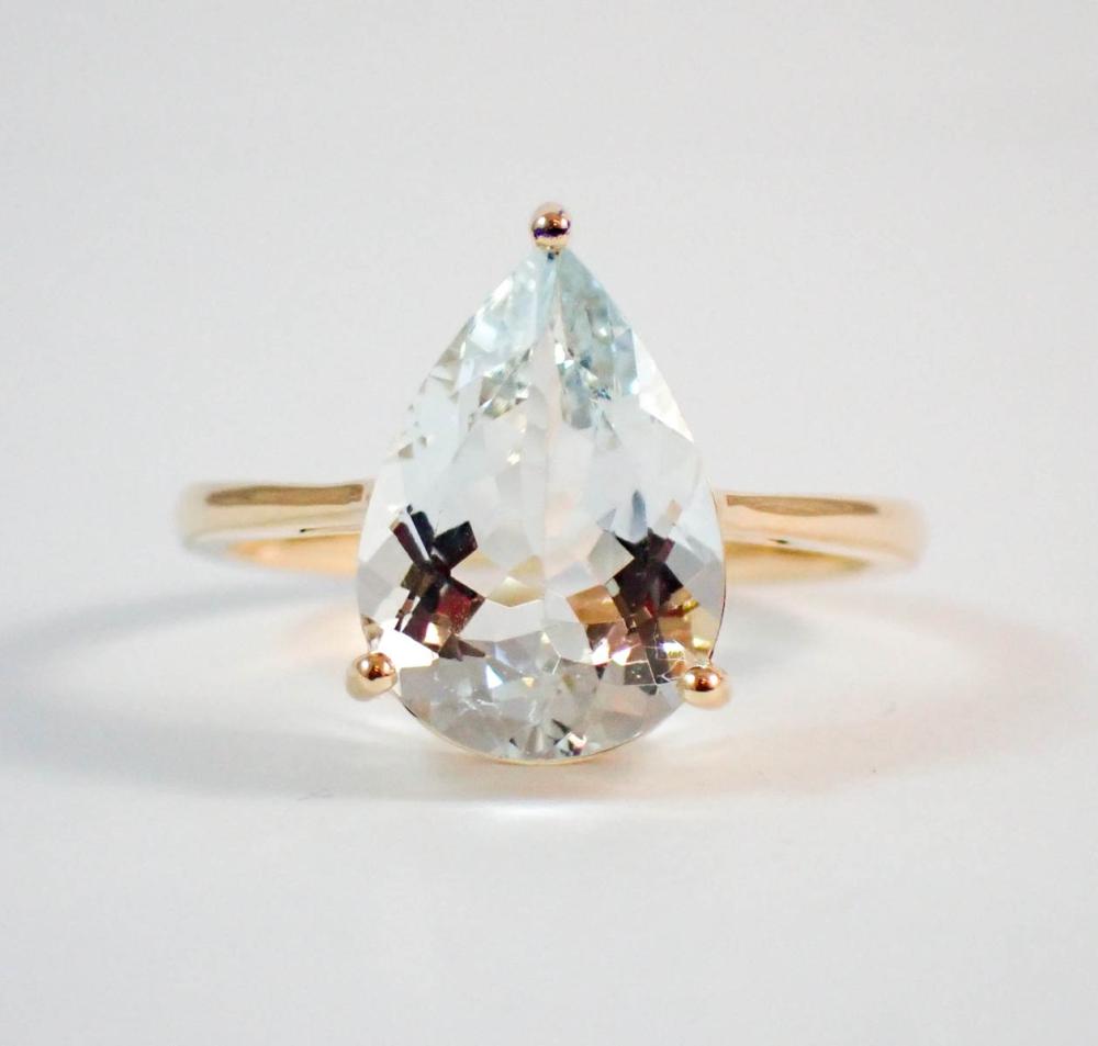 Appraisal: AQUAMARINE AND FOURTEEN KARAT GOLD SOLITAIRE RING with three yellow