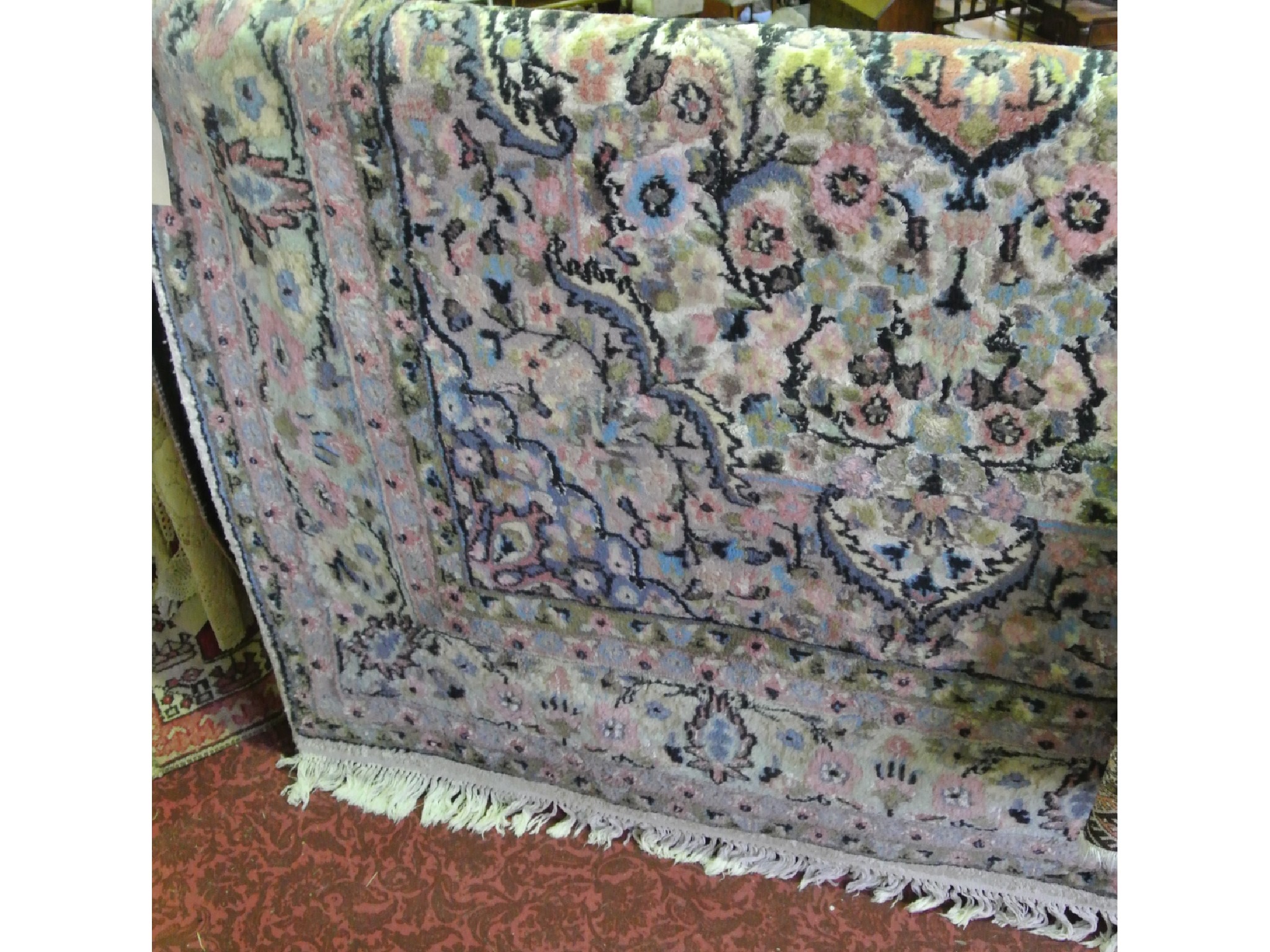 Appraisal: A fringed woven wool carpet with foliate decoration in shades