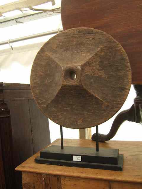 Appraisal: A CIRCULAR TURNED AND CARVED SCULPTURAL WHEEL on a stepped