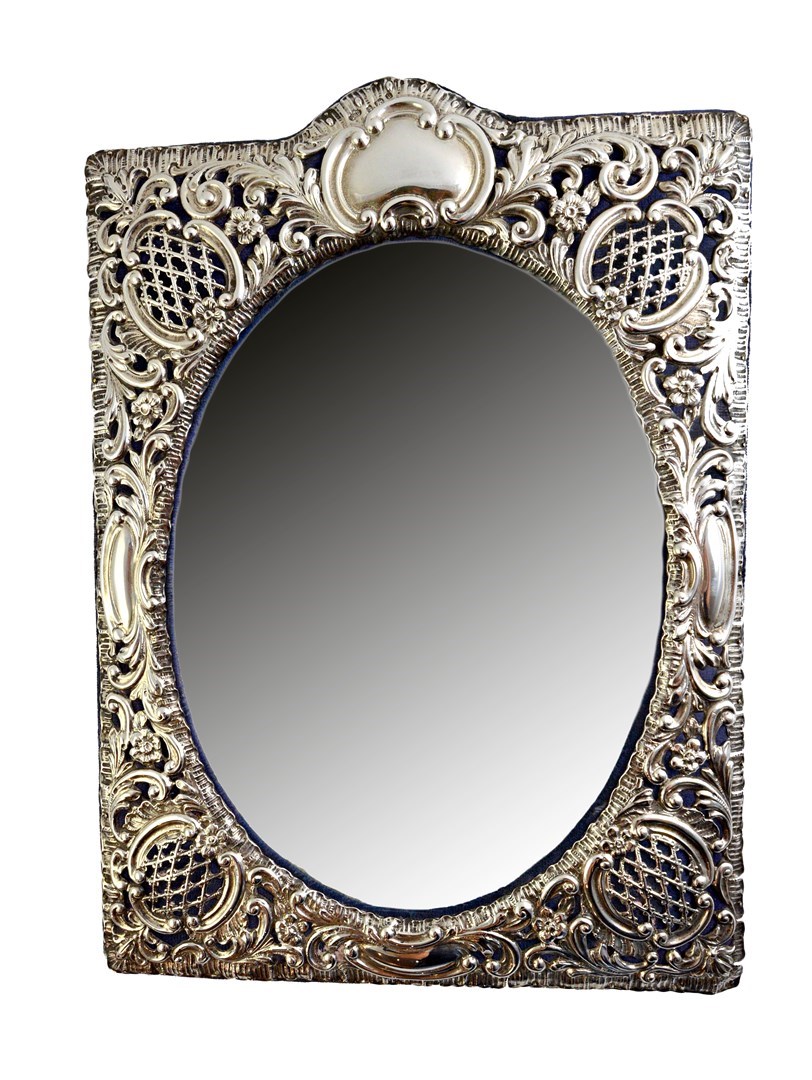 Appraisal: A silver mounted shaped rectangular strut backed mirror fitted with