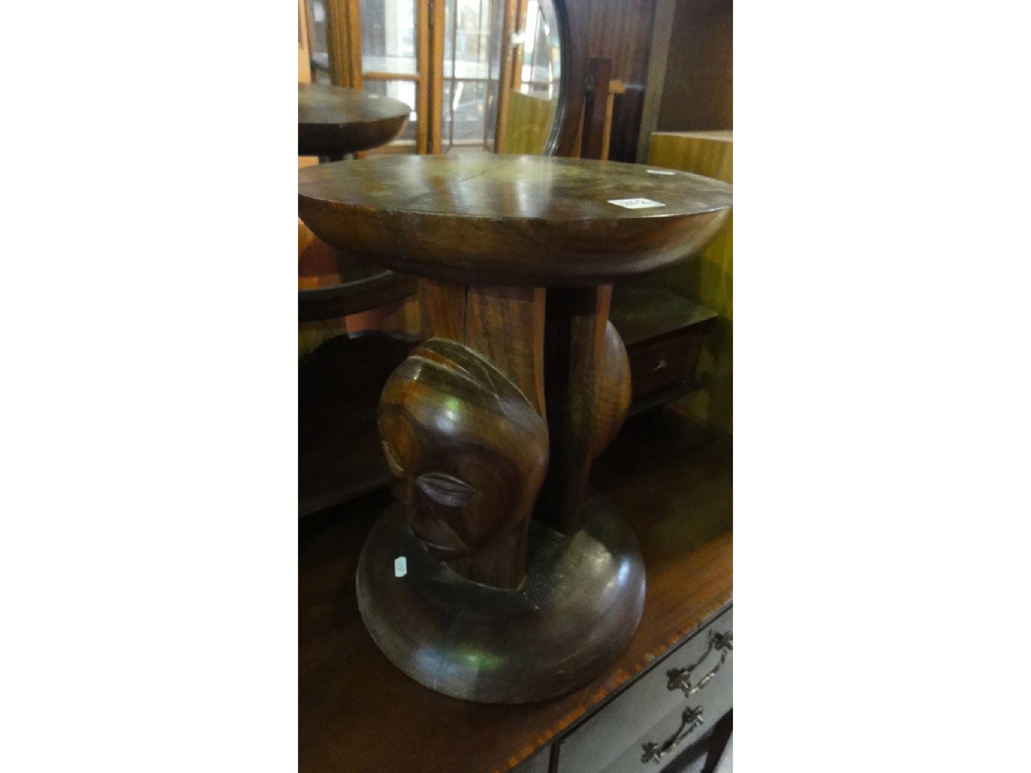 Appraisal: An African hardwood stool of circular form with carved face