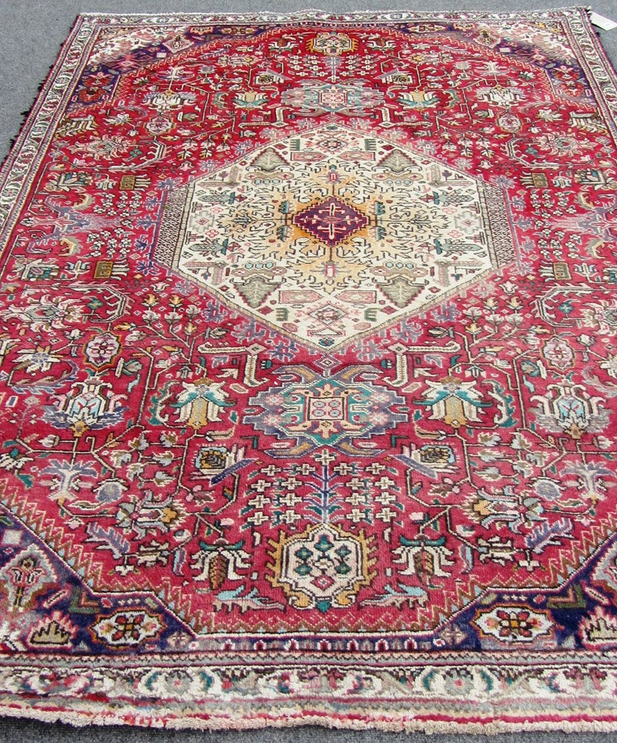 Appraisal: A Tabriz rug Persian the madder field with a bold