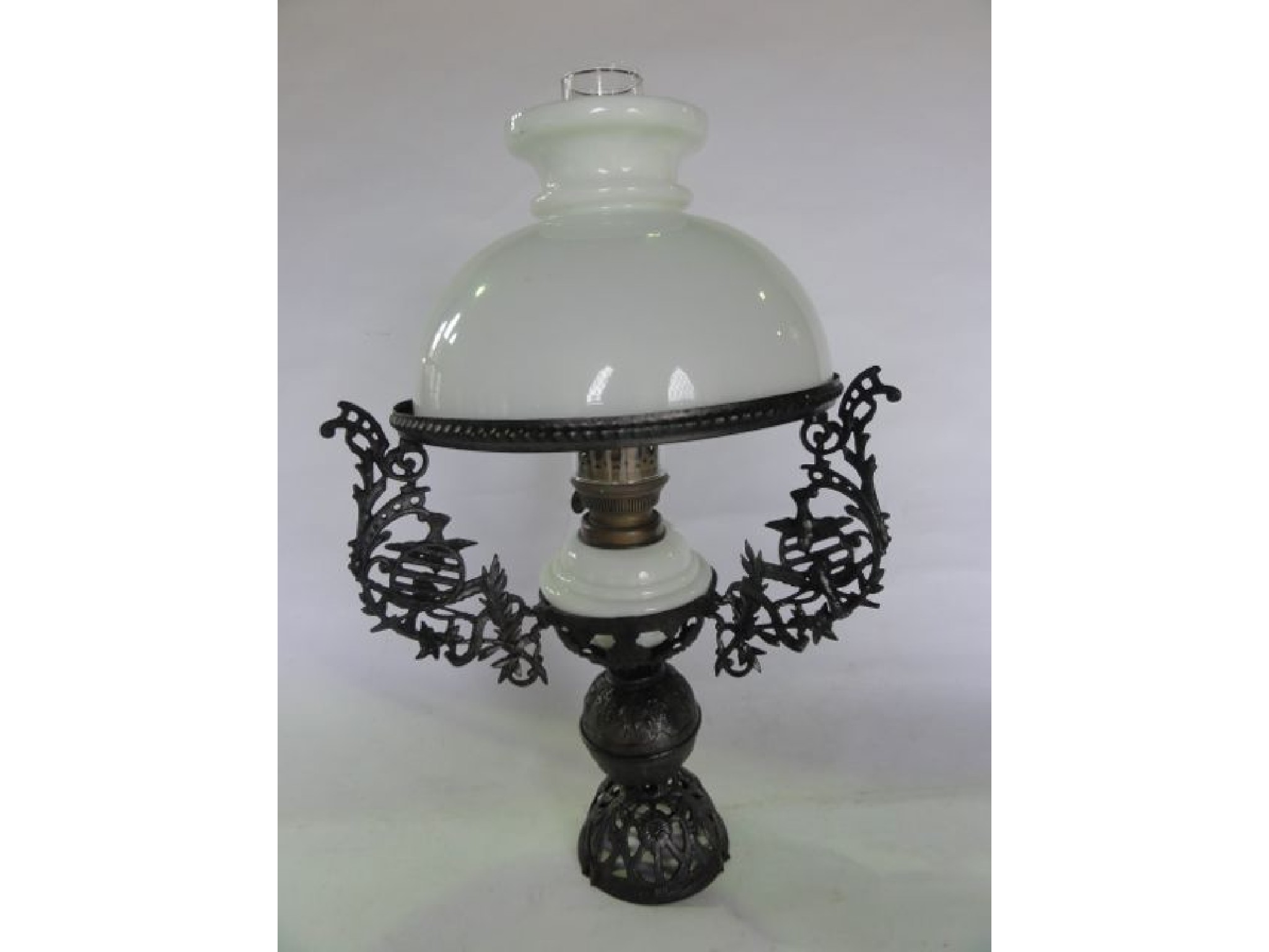 Appraisal: An oil lamp with opaque glass fount set within an