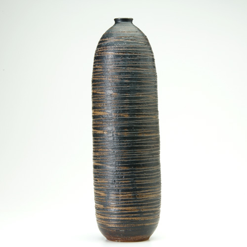 Appraisal: PETER VOULKOS Tall ridged stoneware bottle covered in gunmetal glaze