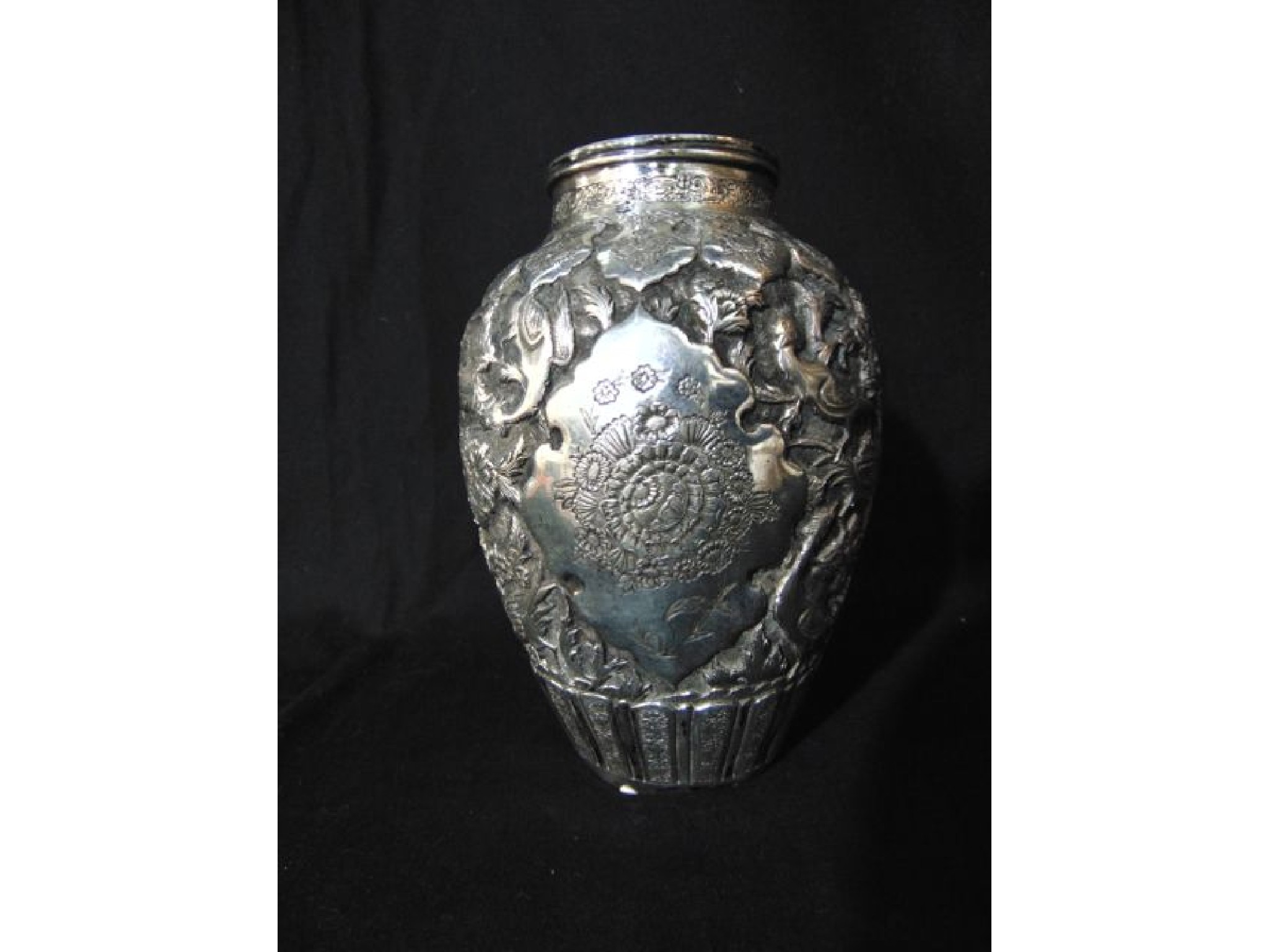 Appraisal: A possibly Persian silver vase the ovoid body embossed with