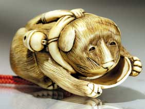 Appraisal: CARVED IVORY NETSUKE Carved ivory netsuke of a dog with