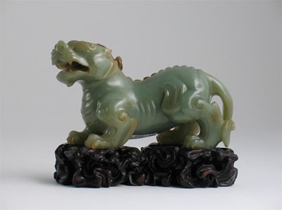 Appraisal: A Chinese celadon-coloured jade carving of a mythical beast baring