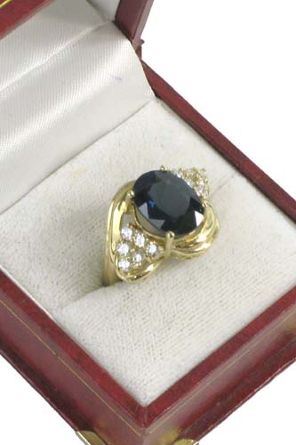 Appraisal: SAPPHIRE DIAMOND AND K GOLD RING centering an oval-cut blue