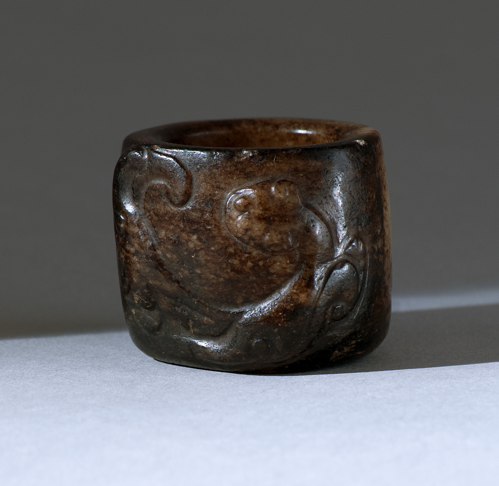 Appraisal: BROWN AND WHITE JADE THUMB RING th CenturyWith relief qilin