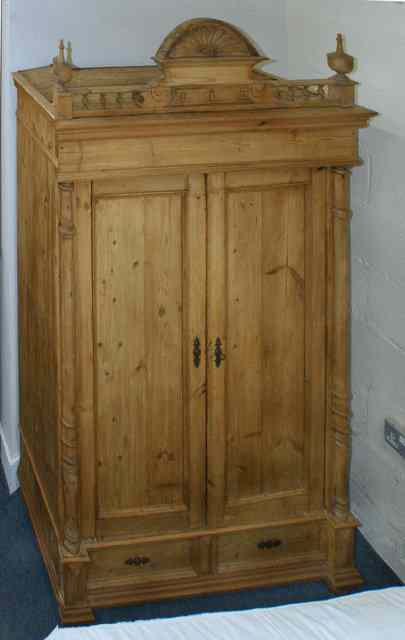 Appraisal: A CONTINENTAL PINE ARMOIRE the carved arching pediment over two